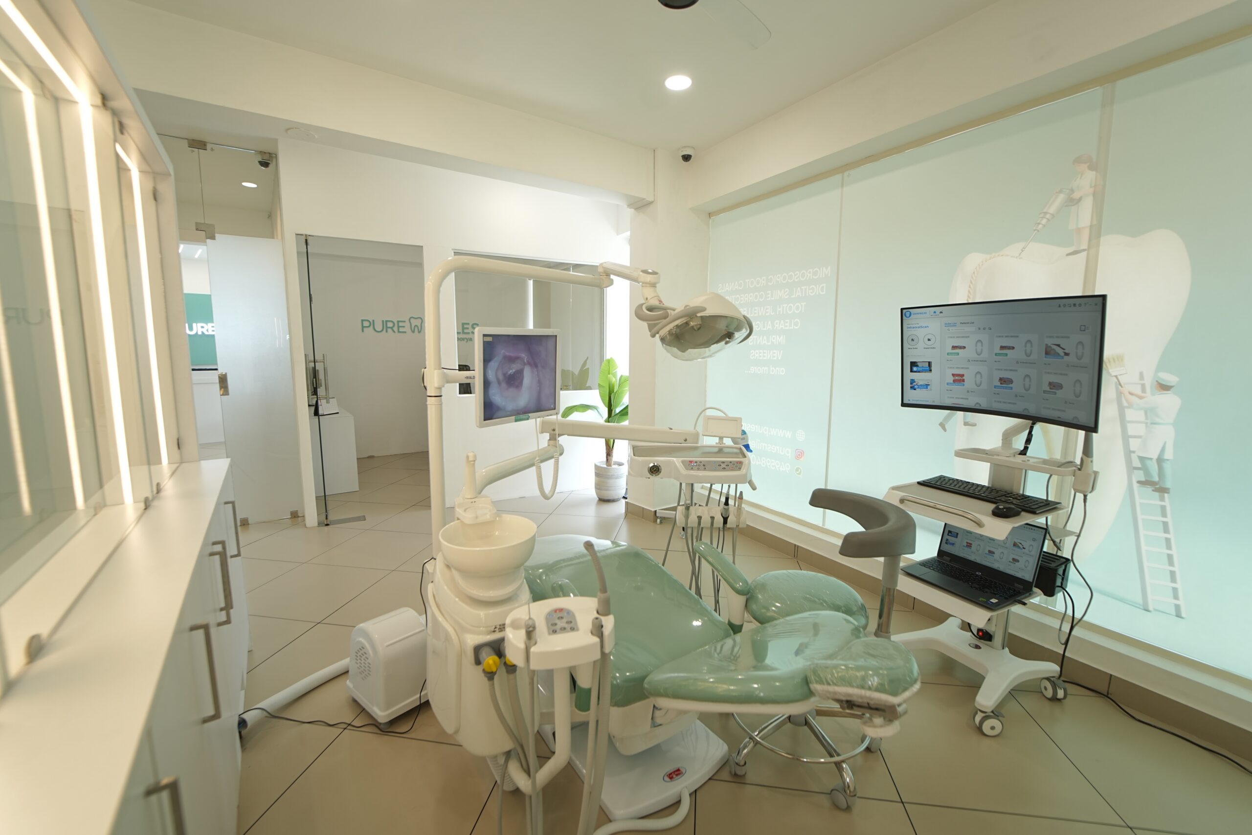 Modern dental clinic room with advanced equipment and digital monitors.